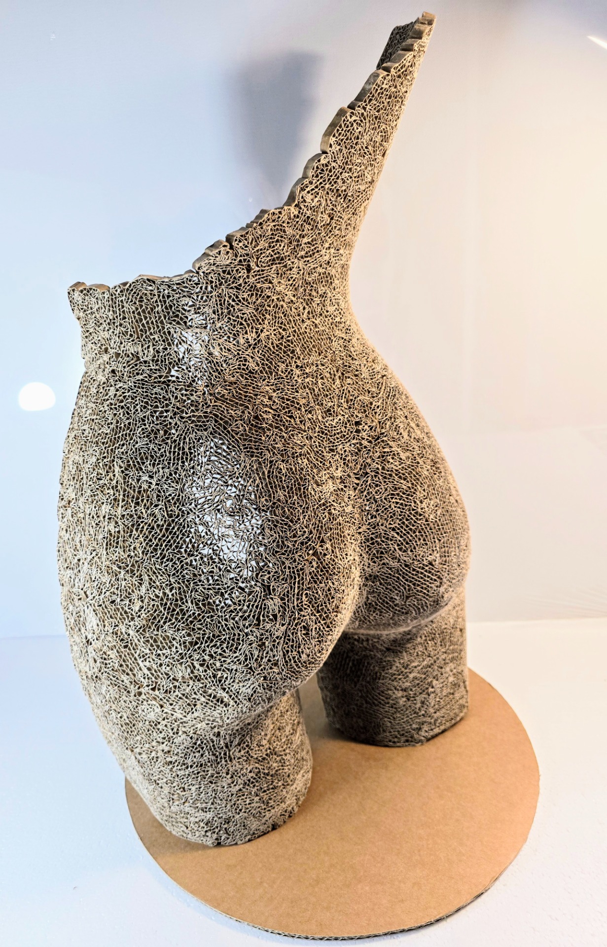 "La poésie de la matière" Illustre la parfaite symbiose entre l’art et le matériau, un hommage à la délicatesse et à la structure du carton transformé. À travers cette œuvre, chaque découpe et chaque entrelacs racontent une histoire où le vide dialogue avec le plein, et où la lumière, en passant à travers les motifs ajourés, dévoile des ombres dansantes. La dentelle de carton, fragilité apparente mais force sculpturale, devient un langage subtil où la main de l’artisan transcende la matière brute en une ode à la beauté.